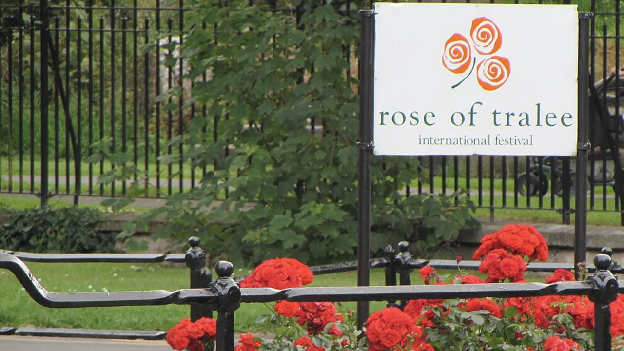 The Rose of Tralee International Festival sign above a bed of red roses in Tralee, County Kerry